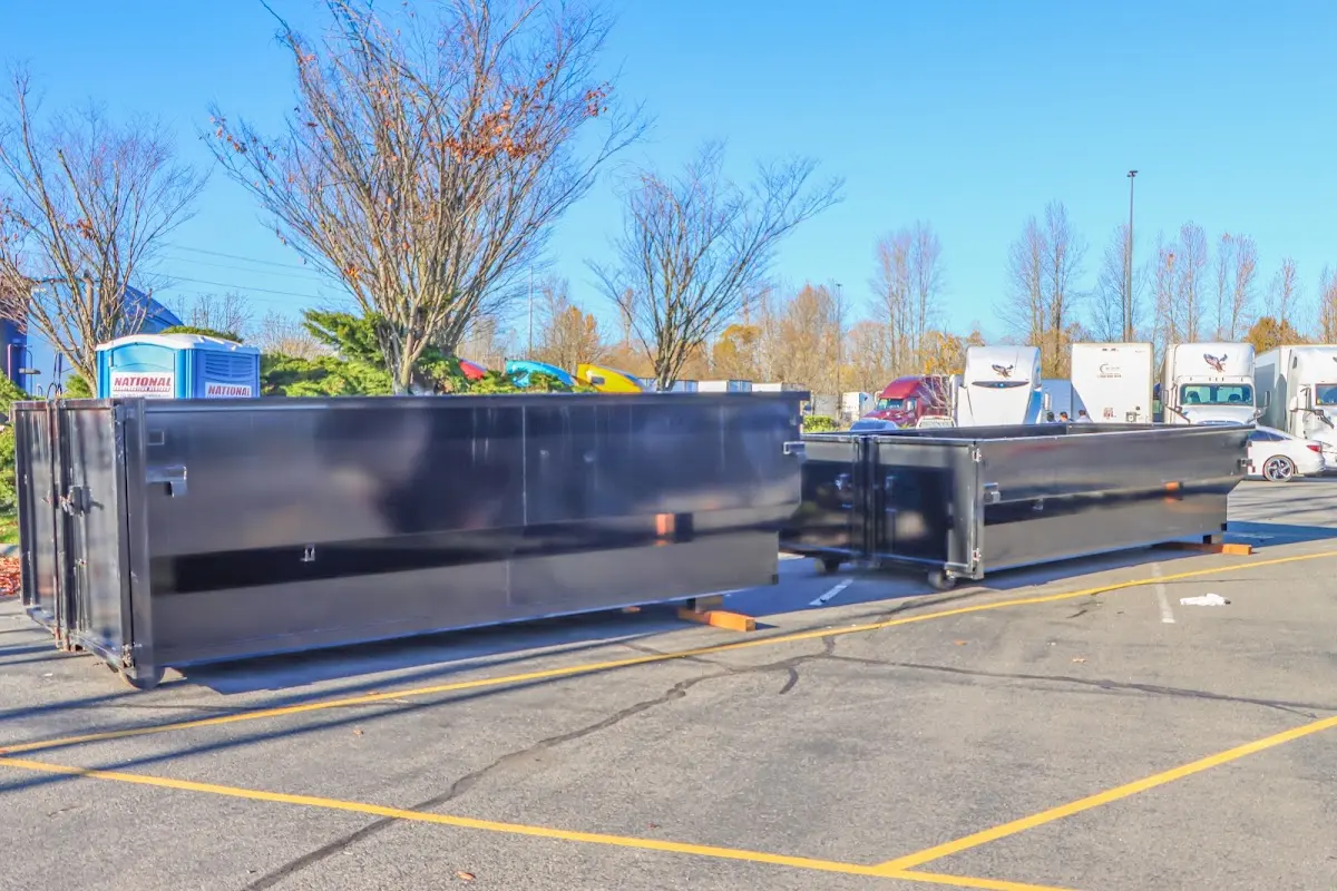 Professional dumpster rental service with roll-off container on residential driveway in Bear
